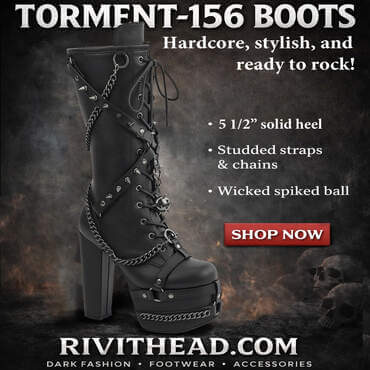 Black knee high platform boot with tall block heel, lace-up front, crossing spiked harness straps, hanging chains, side ring hardware, and a dangling spiked ball charm.