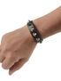 Black leather wristband with cone spikes worn on a person's wrist