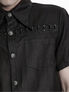 Black short sleeve shirt with button front, chest pocket, and decorative metal details