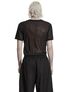 Back view of a black mesh shirt worn with black pants