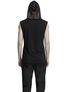 Back view of black sleeveless hooded shirt worn with black pants
