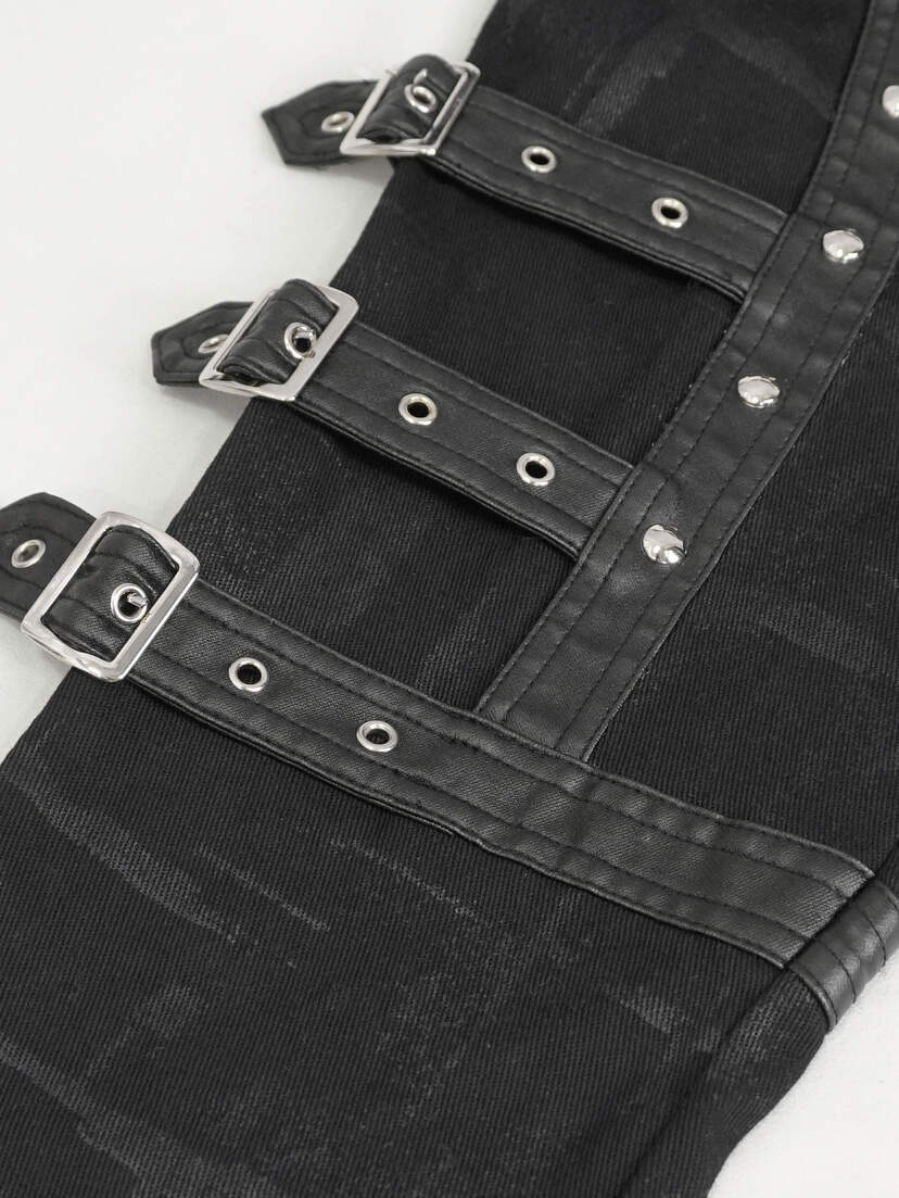 Close-up of black women's punk pants featuring multiple straps and silver buckles.