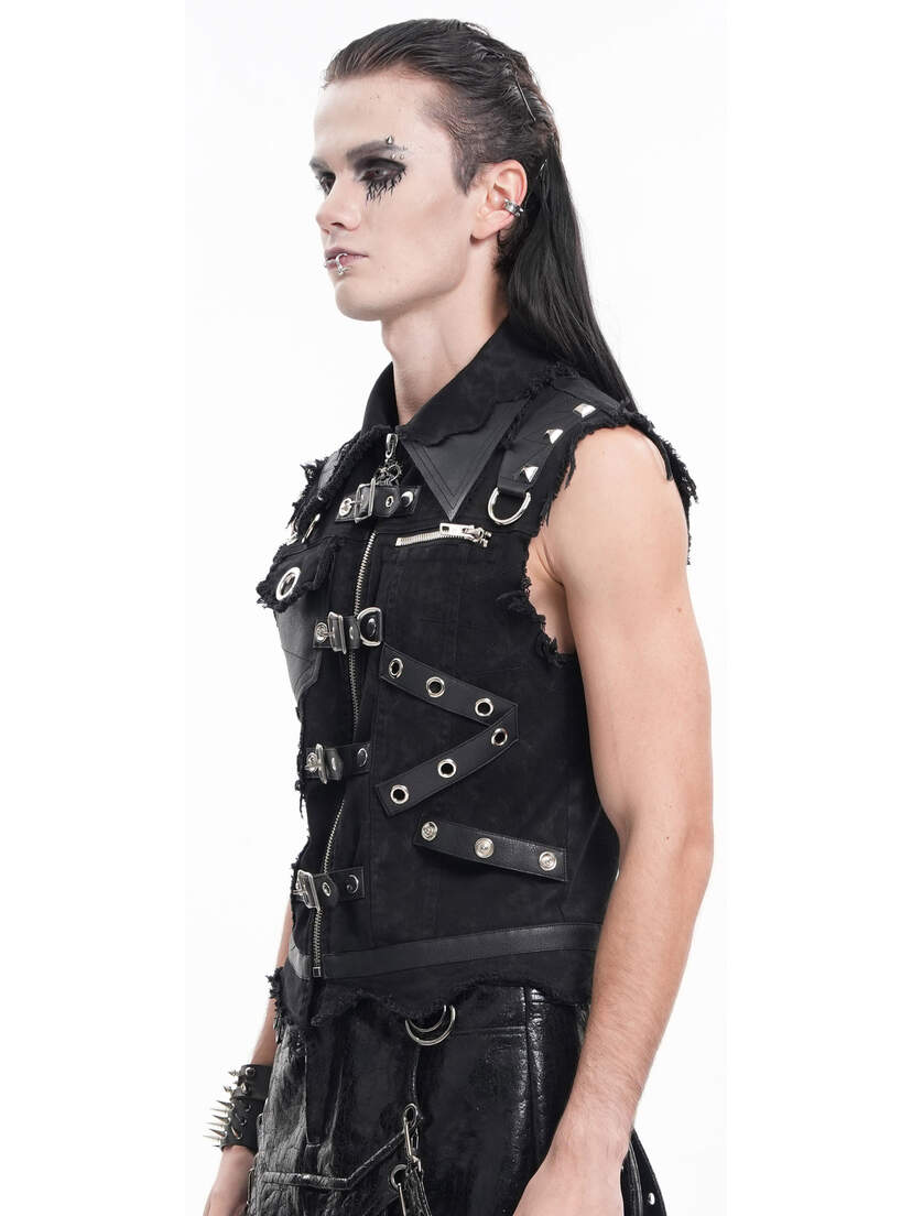 Badlands Strap Vest Side view of a black vest with studs and straps, worn by a model with long hair and makeup.