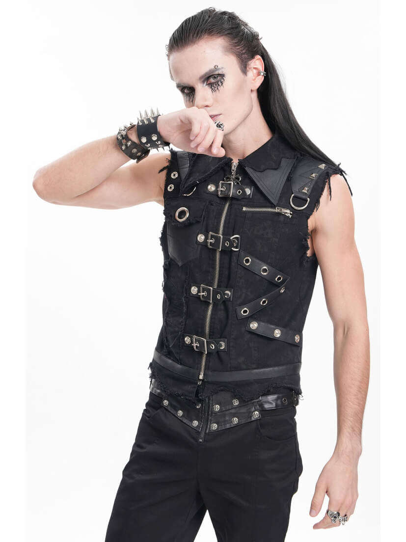Badlands Strap Vest A model wearing a black strap vest with metal accents and studs, posing with a hand to the face.