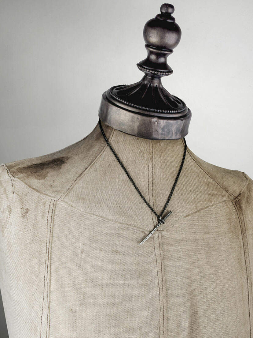 Close-up of Bushido Pendant Necklace with a black chain and sword-shaped pendant on a mannequin bust