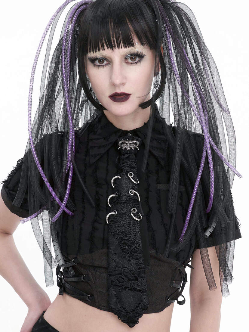 A model wearing a black cropped top with lace-up details and long black and purple hair extensions.