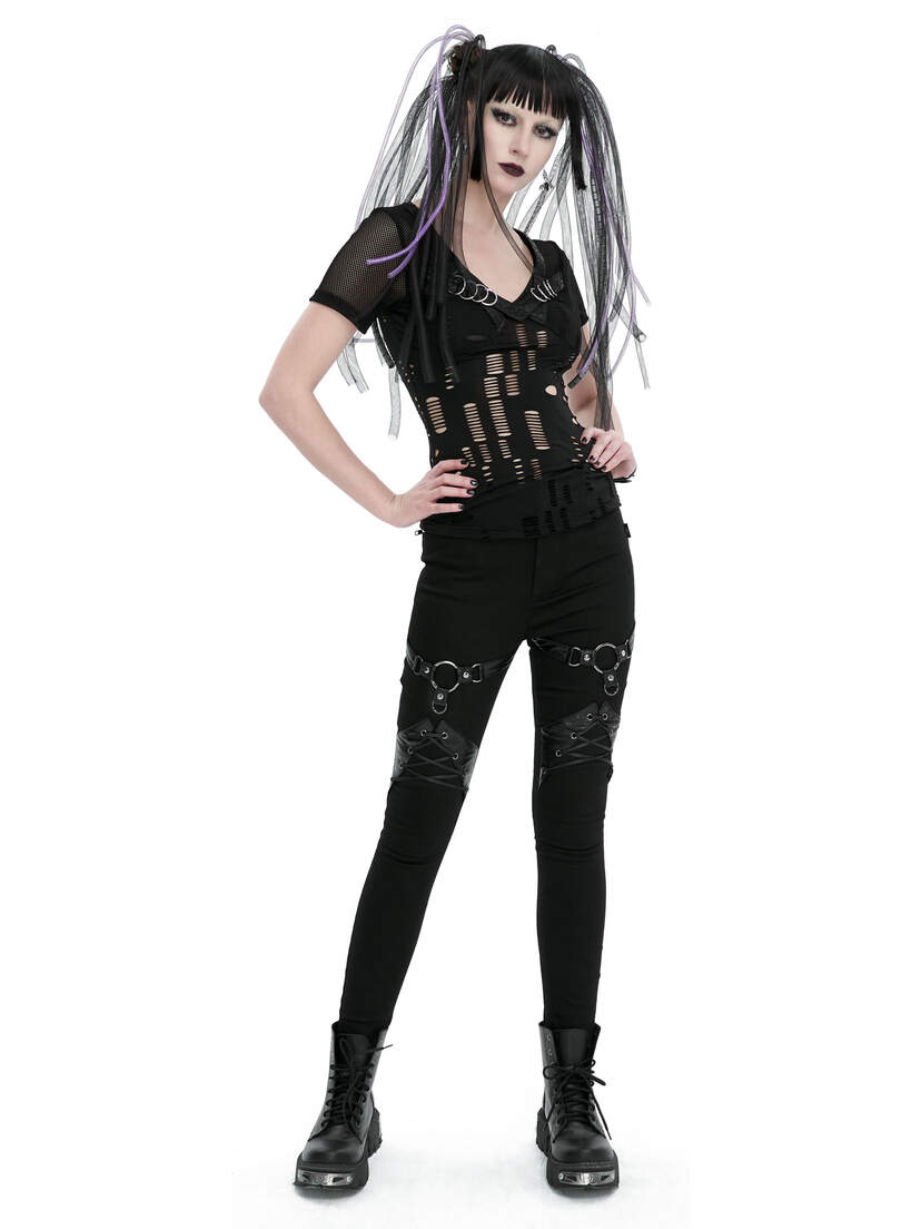 Model wearing black Vivian Harness Pants with a fitted top and combat boots, posing confidently.