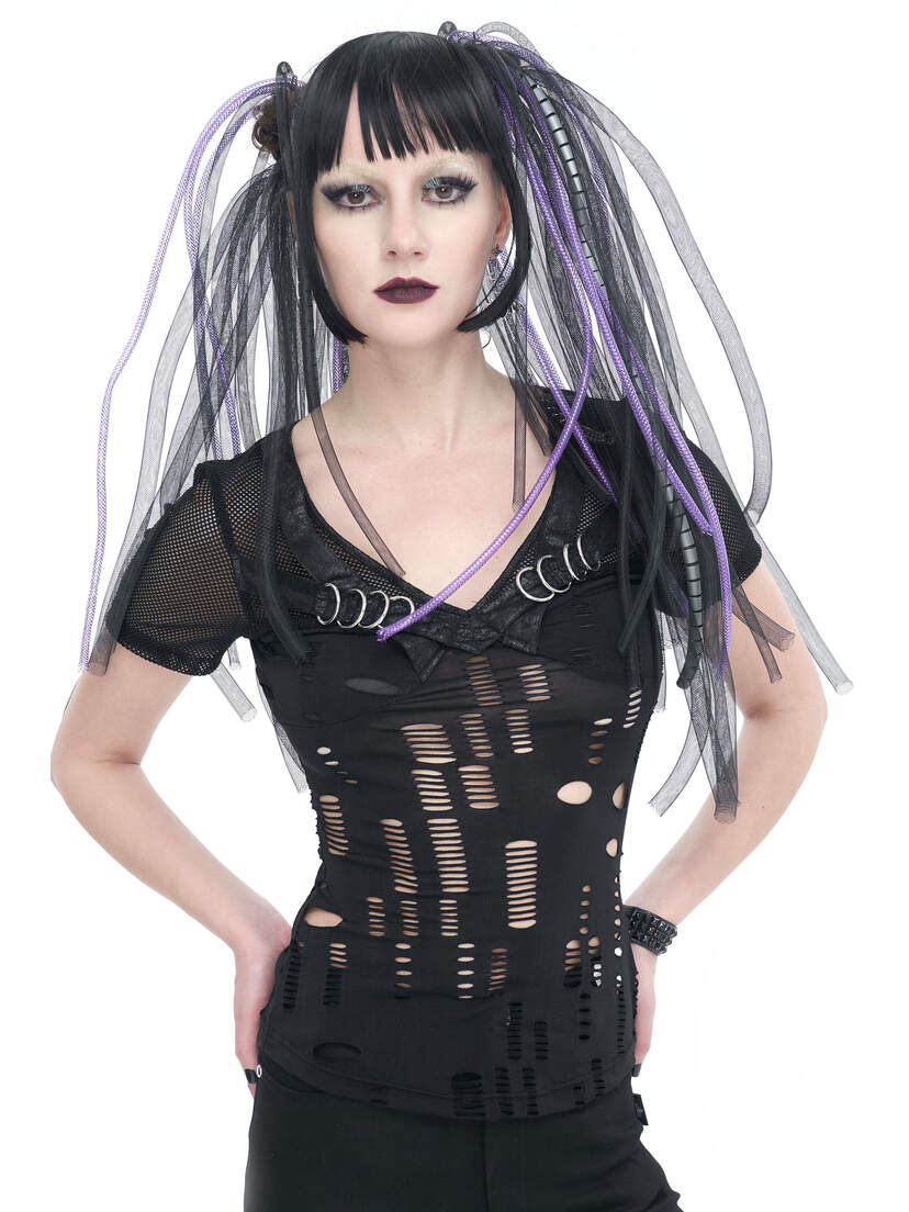 A model wearing a black slashed top with a deep V-neck and cut-out details, styled with long hair extensions.