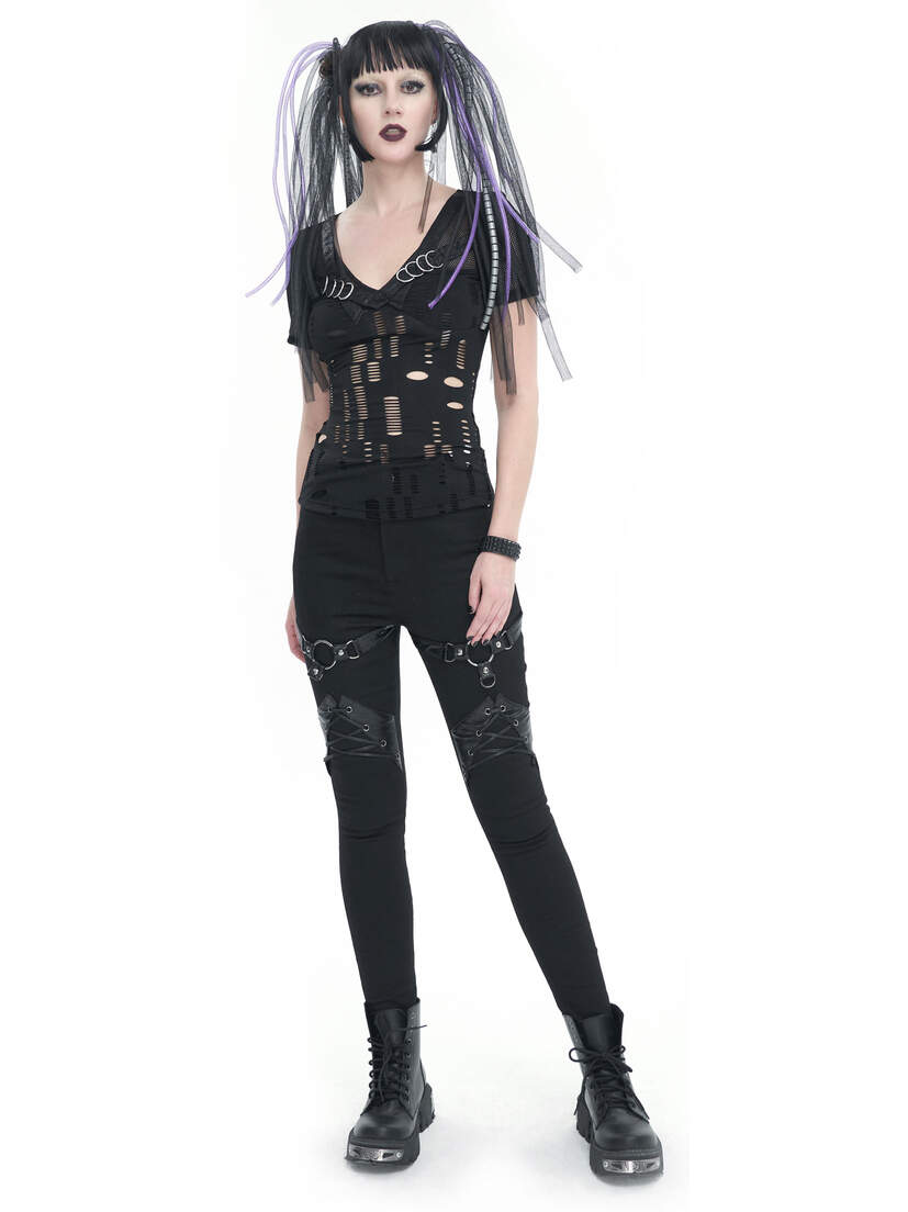 Model wearing a black slashed top with a deep V-neck and distressed details, paired with black pants.