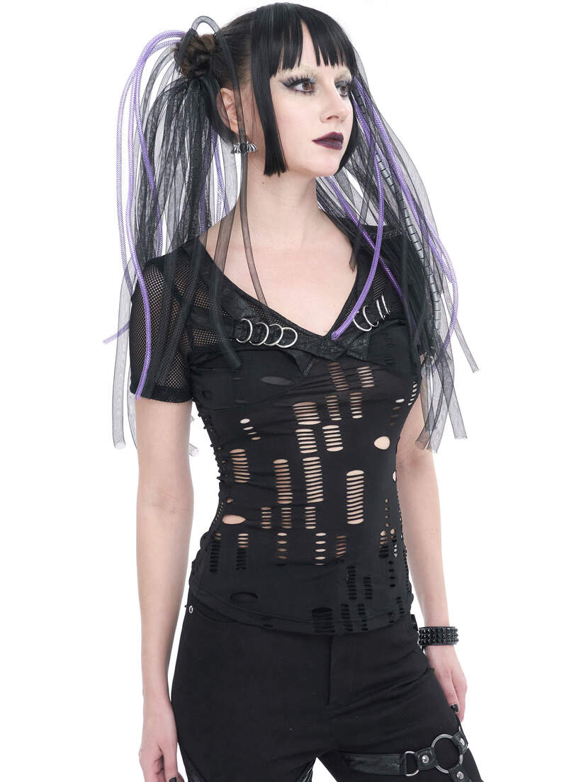 A model wearing a black slashed top with cutouts and purple accents, styled with long hair.