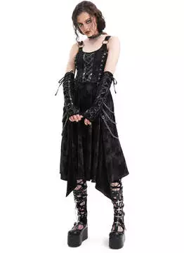 Close-up of black velvet gothic dress with silver chain and skull embellishments, arm warmers attached