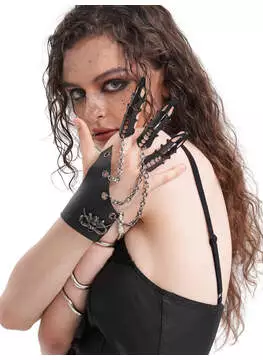Close-up of The Devil's Claw jewelry piece with silver chains and skull charms on black leather