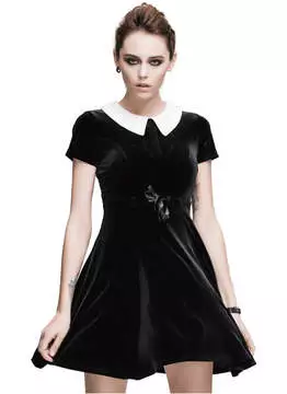Front view of a woman wearing a black velvet dress with short sleeves and a white collar